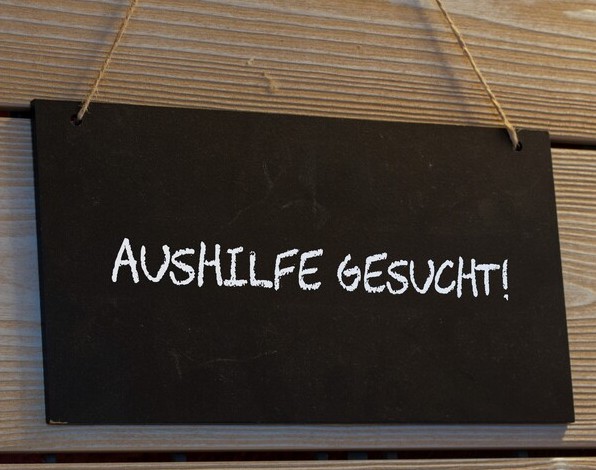 Nahaufnahme von einem Schild mit der Aufschrift AUSHILFE GESUCHT
